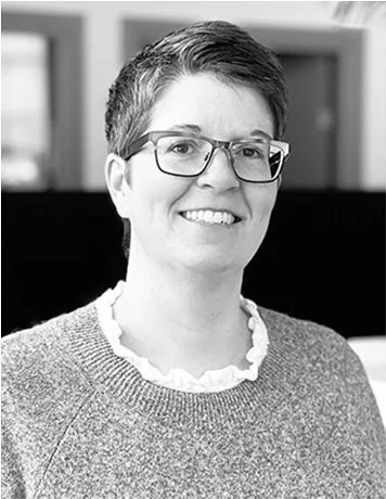 Madelene Larneby står i kontorsmiljö och tittar in i kameran