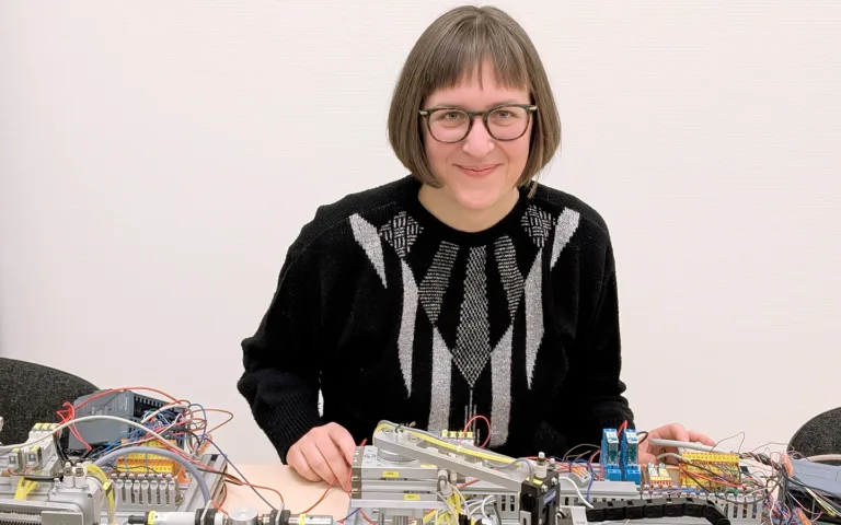 Sara Svensson sitter framför teknisk utrustning där hon kan träna på automatiserade flöden.