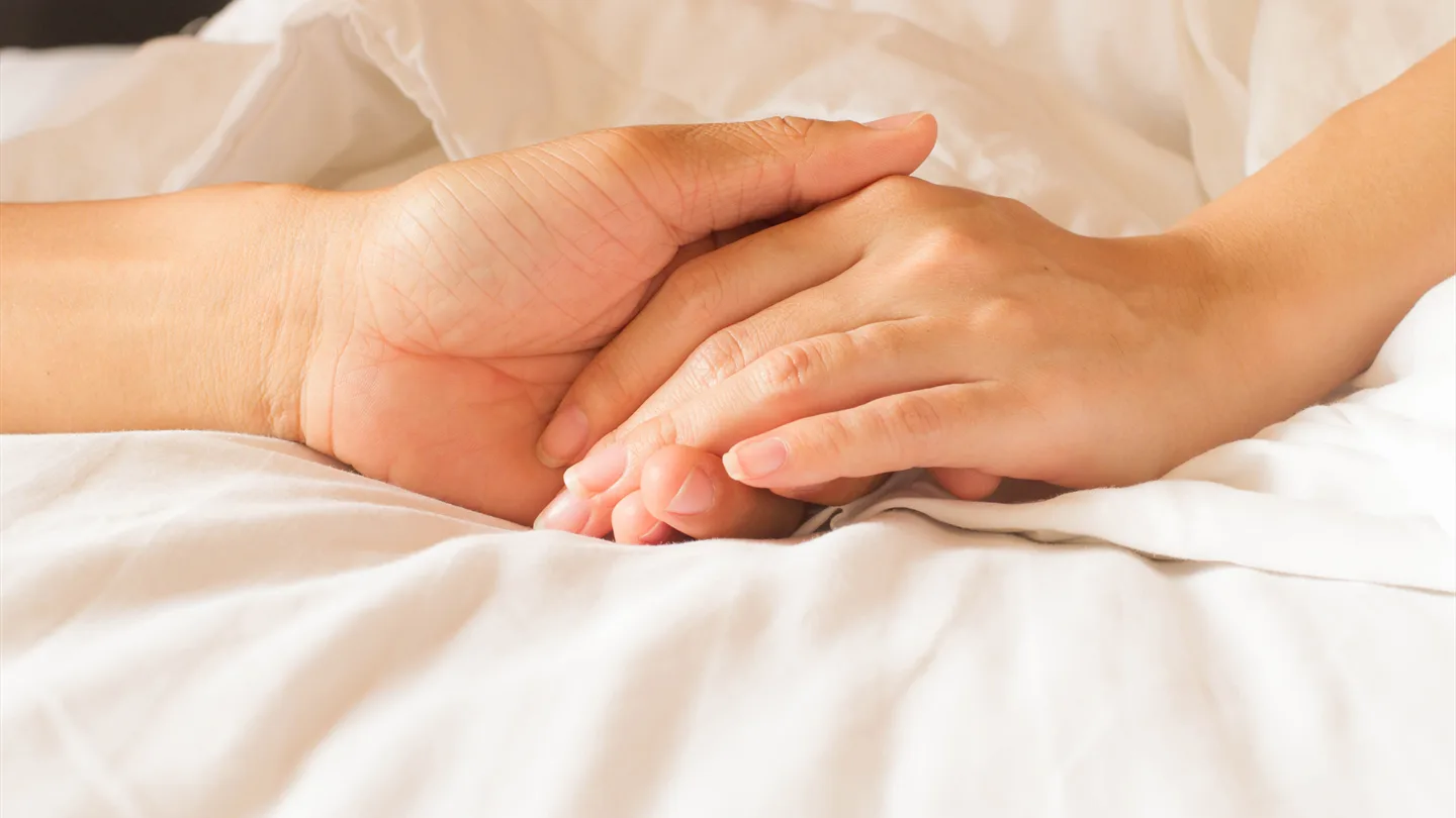 Händer som håller om varandra i livets slutskede.