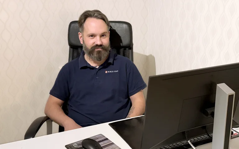 Daniel Axelsson, som utbildar sig till specialistundersköterska inom psykiatri sitter vid ett skrivbord och tittar in i kameran.