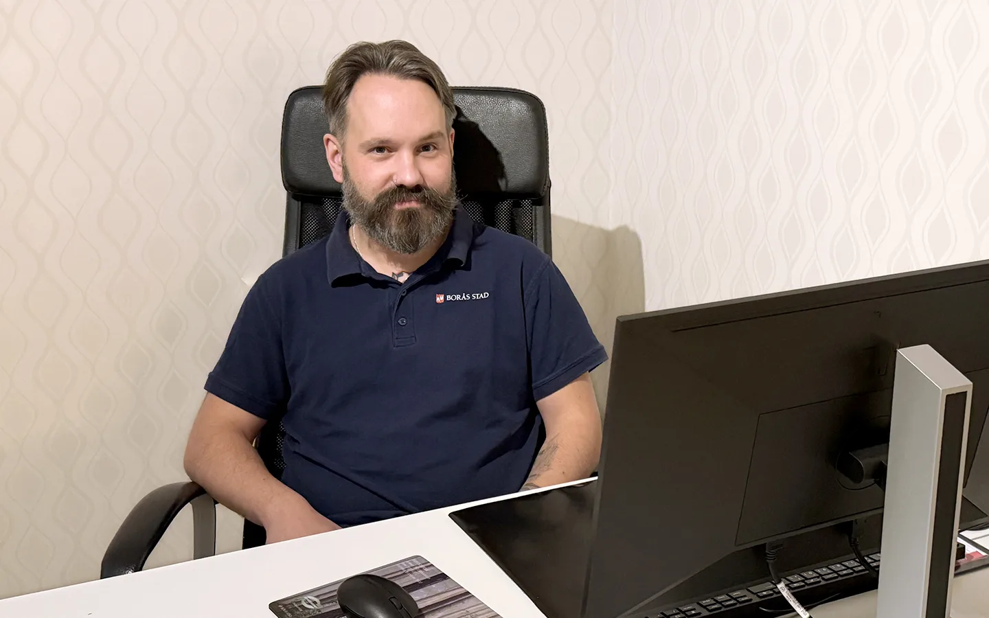 Daniel Axelsson, som utbildar sig till specialistundersköterska inom psykiatri sitter vid ett skrivbord och tittar in i kameran.